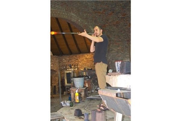 Sehr gespannt schauen die Kids zu, wie der Glasbläser seine Arbeit verrichtet. Zunächst pustet er einen Hohlraum in die heiße Glasmasse. Foto: möh